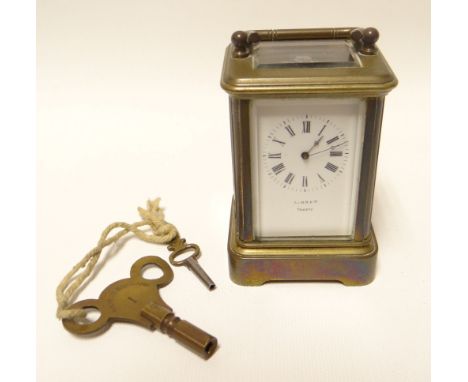 A miniature brass Swiss movement carriage clock with white enamel dial bearing Roman numerals, 3.5ins high (9cms)