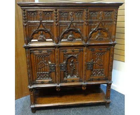 A Jacobean-revival oak court cupboard, the two stages raised above a shelf-base, the upper stage accessed by a pair of side d