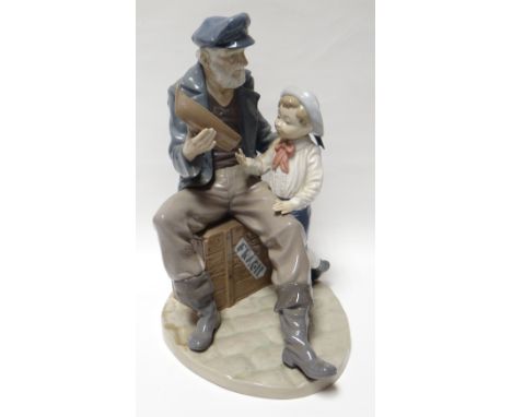 A Lladro model of a seated ‘old salt’ romanticising about the sea with a model boat in his hand and in the company of a young
