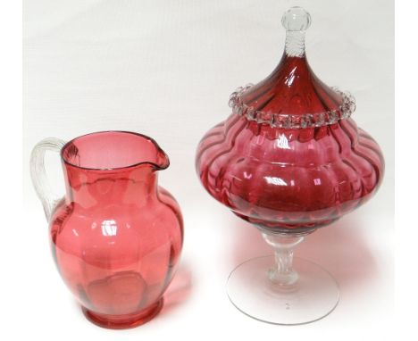 A good cranberry glass covered bowl with clear glass stem, foot and finial, 13ins high (33cms); together with a cranberry gla