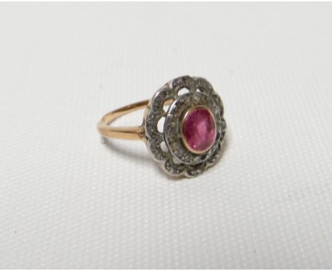 An early twentieth century floral diamond and ruby ring, the shank in unmarked yellow gold (believed), 3.76gms