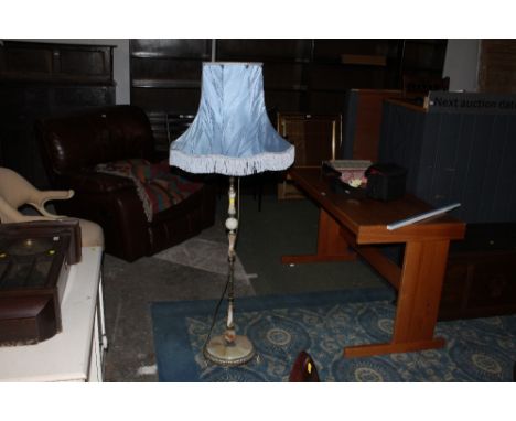An onyx and brass standard lamp with blue tasseled shade