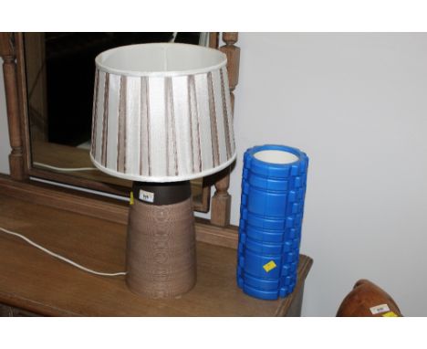 A studio pottery table lamp with brown and white coloured shade together with blue exercise roller