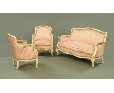 A three piece cream painted lounge suite comprising sofa and two arm chairs upholstered in pink foliate patterned material, t