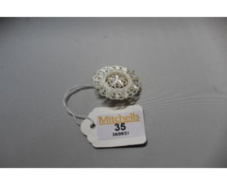 A circular mother of pearl pierced brooch  