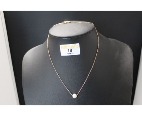 A cultured pearl pendant on gold coloured chain