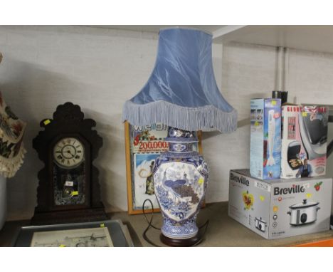 A large modern decorative blue and white table lamp decorated with peacocks 