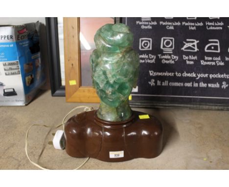 A green glass table lamp on plastic stand