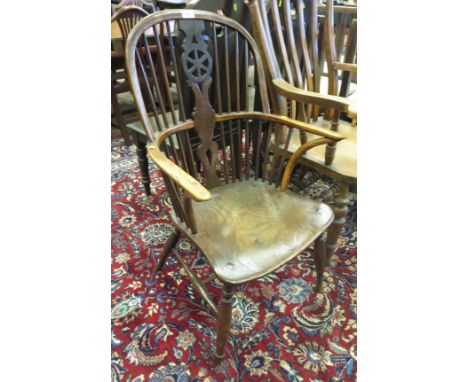 An early 19th Century Windsor Elbow Chair in ash and elm, etc with pierced wheel and stick back, solid seat on turned legs, w