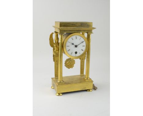 A small French Mantel Clock in a gilt case, white enamel dial, on two front pillars and sphinx supports to back, on an oblong
