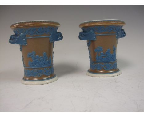 A small pair of Spode Vases with moulded applied decoration of scenes of cherubs, scroll bands, two dolphin handles in blue o