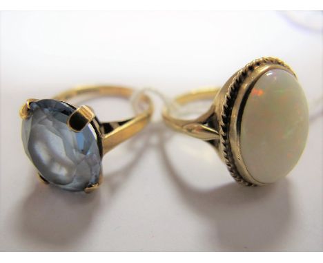 A Modern 9ct Gold Single Stone Opal Dress Ring, oval collet set; together with another 9ct gold dress ring. (2) 