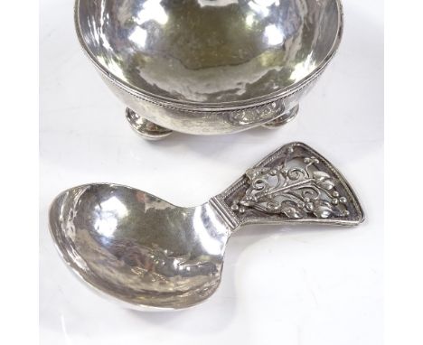 An Arts and Crafts silver caddy spoon and bowl, with pierced stylised floral handle, unmarked but possibly C R Ashbee or Edwa