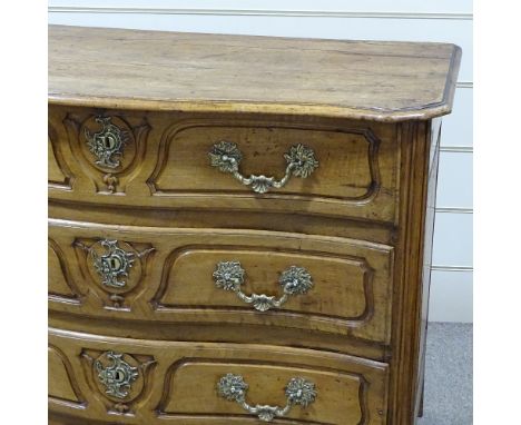 An 18th century French fruitwood serpentine-front 3-drawer commode, with shaped panelled drawer fronts and heavy ormolu drop 