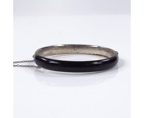 A silver black enamel and split-pearl hinged mourning bangle, with central pearl within a starburst surround, internal diamet