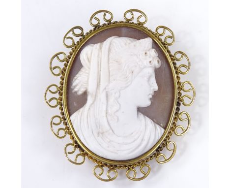 An oval relief carved cameo shell panel brooch, depicting Classical female portrait, in 9ct gold rope twist and openwork fram
