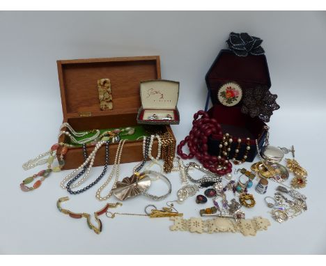 A collection of costume jewellery including jet brooch, silver fob, white metal pot, silver bangle, large silver cross pendan