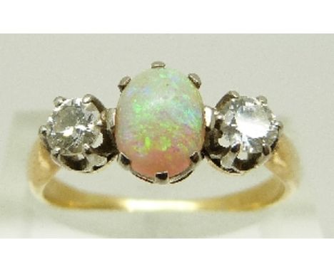 A Victorian / Edwardian ring set with an oval opal cabochon and two old cut diamonds each approximately 0.25ct, size Q, 3.5g