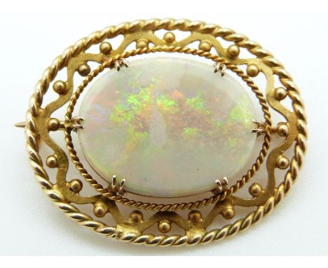 A 9ct gold brooch set with an opal with pierced border 