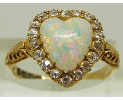 A Victorian 18ct gold ring with pierced shoulders, set with a heart shaped opal surrounded by old cut diamonds, engraved 1897