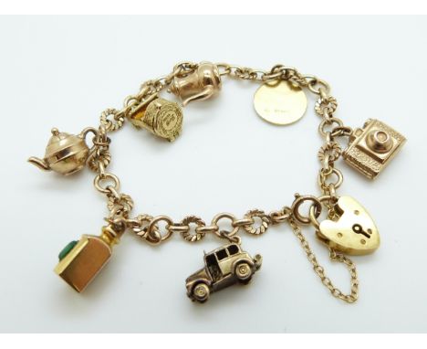 A 9ct gold charm bracelet with seven 9ct gold charms including St Christopher, wishing well, taxi opening to reveal two peopl