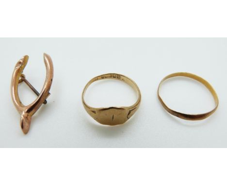 A 9ct gold wishbone brooch, 9ct gold signet ring (2.9g) and a yellow metal band (1g)