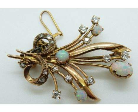 A gold brooch set with four opal cabochons and diamonds in a stylized bouquet design