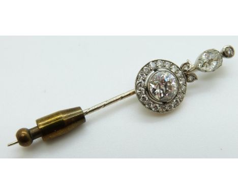 A late Victorian stick pin set with a round cut diamond measuring approximately 1ct within a border of further diamonds and s