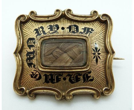A Georgian brooch set with plaited hair surrounded by black enamel writing "In memory of" verso "Mary Stanley Obt August 21st
