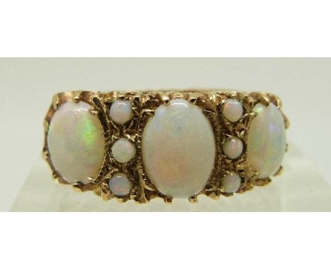 A 9ct gold ring set with three oval opals and six round opal cabochons, size O, 3.6g. 