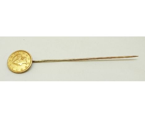 A yellow metal stick pin set with a United States of America one dollar 