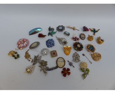 A collection of brooches including Art Deco, ivory, marcasite and enamel, malachite, amber, paste etc