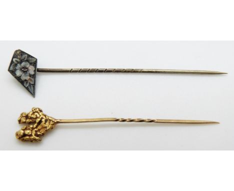 A yellow metal stick pin set with a gold nugget (2.7g) and a silver stick pin with engraved floral decoration 