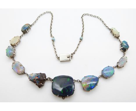 A white metal necklace set with eleven opal cabochons 