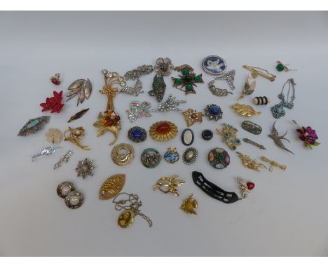 A collection of brooches including 1950s examples, thistle, enamel and swallow examples, enamel scarf clip, banded agate butt