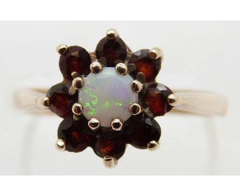 A 9ct gold ring set with an opal surrounded by garnets, size L, 2.4g