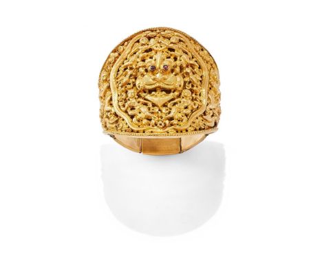 A LATE 19TH CENTURY INDIAN HINGED GOLD BRACELET  The bangle with a broad tapered front panel with a central pierced Kirtimukh