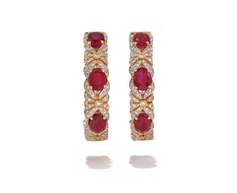 A PAIR OF RUBY AND DIAMOND HOOP EARRINGS Each hoop set to the front and inside back with three oval cut rubies between pierce