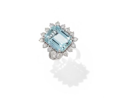 AN AQUAMARINE AND DIAMOND CLUSTER RING The rectangular step cut aquamarine with canted corners, within a brilliant cut diamon