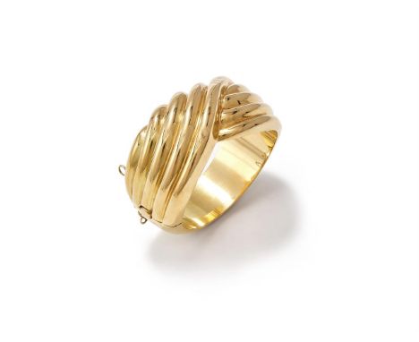 AN ITALIAN HINGED BANGLE  The polished reeded crossover bangle to a tapered back, Italian control marks and 750  Size/dimensi