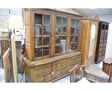 A good quality reproduction oak Georgian style bookcase by OakwoodHaving a moulded cornice above three panelled glazed doors 