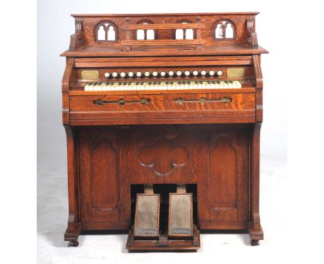 An early 20th Century oak cased harmonium by Imperial of LondonHaving an openwork galleried top enclosing a music stand above