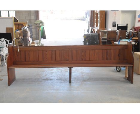 A Victorian pitch pine church pewRaised on two end bracket supports and fitted with a rear rail book trough, 227cm long (repa