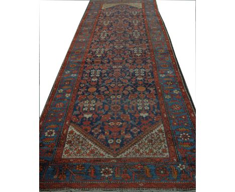 A Kashan style carpetThe rectangular form carpet with predominantly red and blue ground with central lozenge detailed with Ar