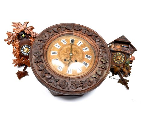 A late 19th/early 20th Century carved black forest oak wall clockThe case carved with flower heads and leaves enclosing the c