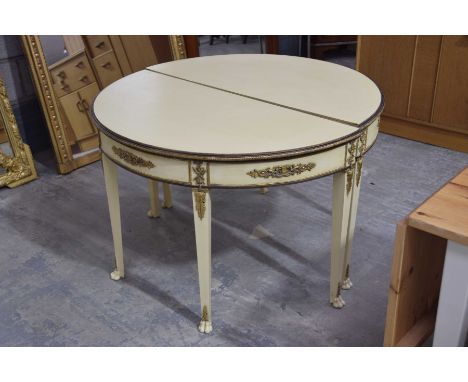 A pair of painted French style demi lune console tablesEach painted in cream with gilt metal banding and appliques raised on 