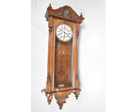 A late 19th Century walnut Vienna wall clockThe architectural case with turned finial's to the top and glazed door revealing 