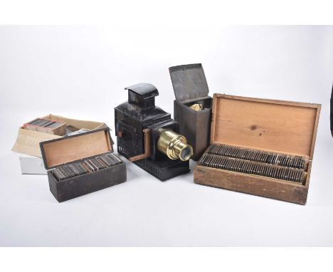 A 19th Century black painted magic lantern With brass lens and outer pierced metal bodies, sold together with a quantity of v