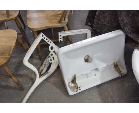 An early 20th Century ceramic basin and iron wall bracketsThe basin with two brass taps supported on a pair of painted iron b