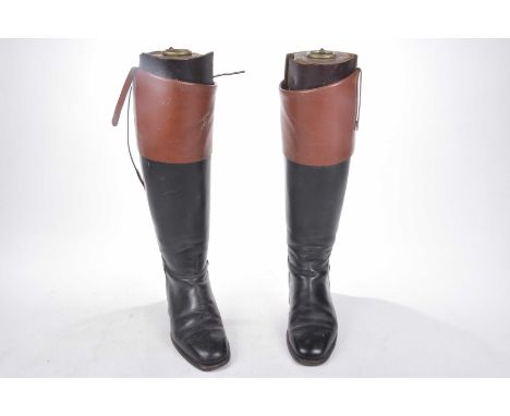 A pair of black and brown hunting boots, 20th Century Complete with trees.